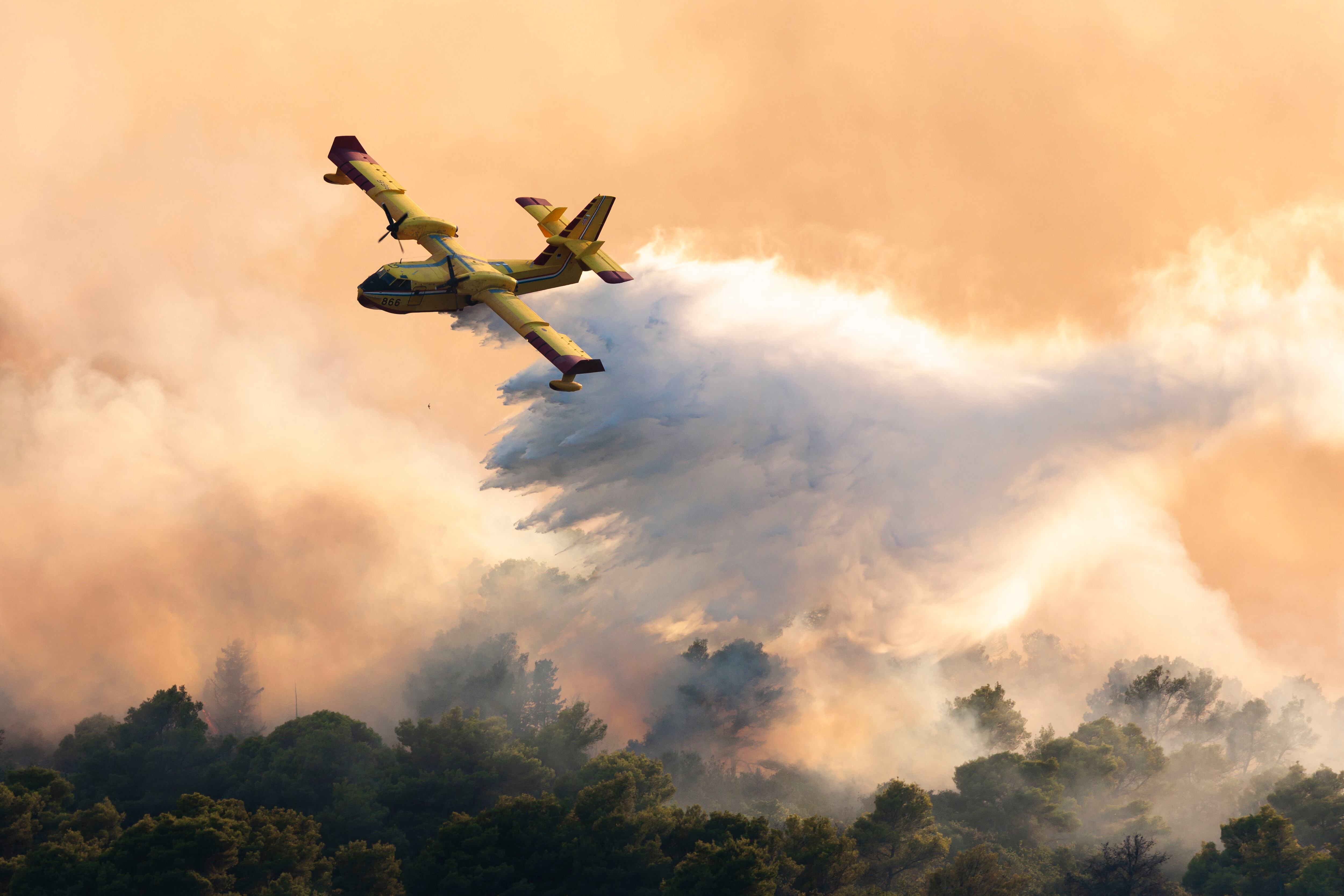Un avión de bomberos echa agua para extinguir un incendio forestal en la isla de Ciovo, Croacia  (AP Foto/Miroslav Lelas)