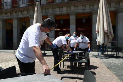 Los empleados de un restaurante miden la distancia entra las mesas de una terraza para cumplir con las normas de distanciamiento social durante el brote de la enfermedad del nuevo coronavirus (COVID-19) en la Plaza Mayor de Madrid, España, el 24 de mayo de 2020. (Foto: REUTERS/Sergio Pérez)