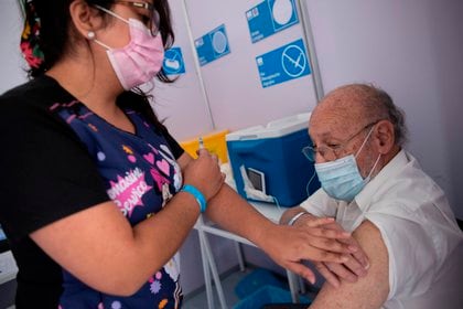 Una enfermera le administra una vacuna contra la covid-19 a un adulto mayor en un centro de vacunación masivo localizado en la comuna de La Florida, hoy en Santiago (Chile). EFE/Alberto Valdés
