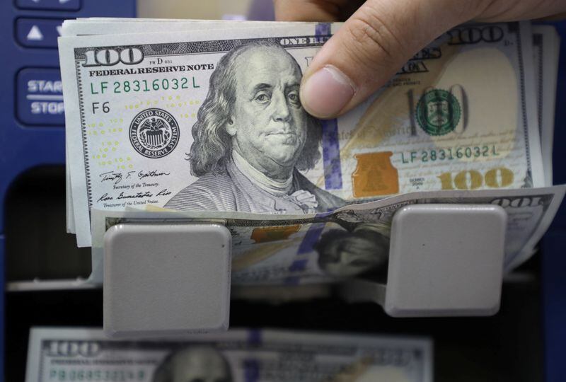 Un hombre cuenta billetes de dólares estadounidenses. REUTERS/Mohamed Azakir