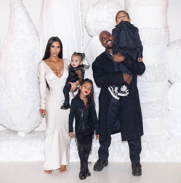 Kim sostiene en brazos a su hija Chicago, mientras que Kanye eleva al pequeÃ±o Saint y de pie, su hija North