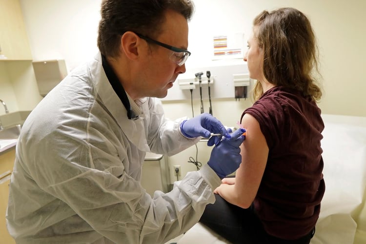 El farmacéutico Michael Witte inyecta a la voluntaria Rebecca Sirull una posible vacuna contra COVID-19, como parte de un ensayo clínico, en el Instituto de Investigación de Kaiser Permanente en Seattle. (AP / Ted S. Warren)