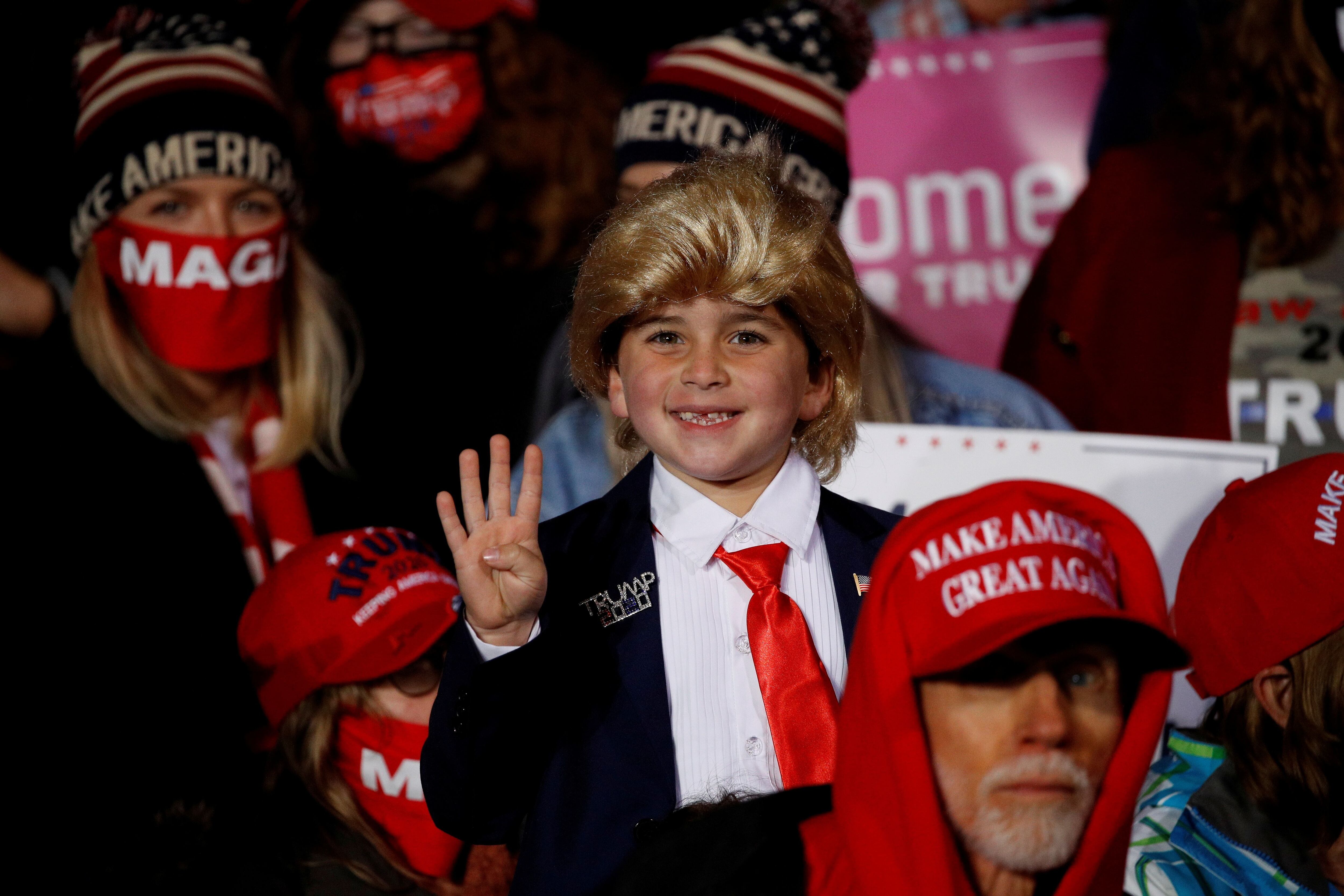 A boy in the audience holds up four fingers during U.S. President Donald Trump's campaign rally at Erie International Airport in Erie, Pennsylvania, U.S., October 20, 2020. REUTERS/Tom Brenner TPX IMAGES OF THE DAY