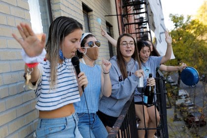 Jóvenes salen al balcón a festejar la victoria demócrata sobre Donald Trump en el barrio Alphabet City de Manhattan, Nueva York. REUTERS/Andrew Kelly