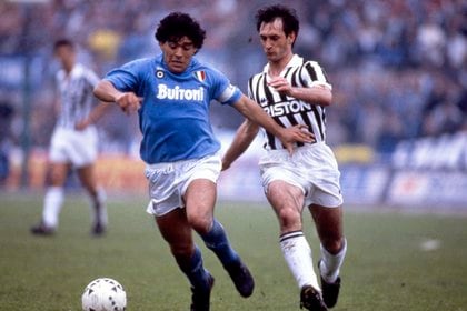 Diego Armando Maradona (Napoli) conduce a su equipo en un partido contra Juventus, en la imagen representado por Luigi De Agostini, en 1988. La empresa italiana de pastas Buitoni, con la que logró el primer Scudetto (Reuters)