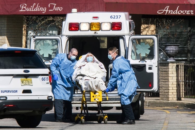 Trabajadores médicos suben a un paciente del Centro de Rehabilitación y Subagudos de Andover en una ambulancia (Eduardo Muñoz Álvarez/Getty Images/AFP)