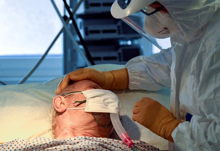 Un médico junto a un paciente que sufre de COVID-19 en la unidad de cuidados intensivos del hospital Circolo de Varese, Italia, el 9 de abril de 2020. (REUTERS/Flavio Lo Scalzo)