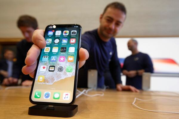 Un empleado de una tienda Apple en Regent Street (Londres) coloca un iPhone X (The Washington Post / Bloomberg / Luke MacGregor)