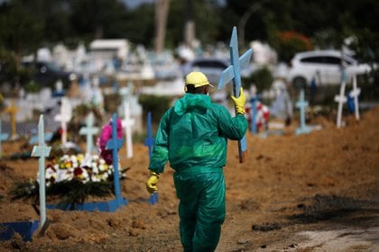 Un sepulturero lleva una cruz en medio del brote de la enfermedad coronavirus (COVID-19), en el cementerio de Parque Taruma en Manaus, Brasil, el 8 de enero de 2021. REUTERS/Bruno Kelly