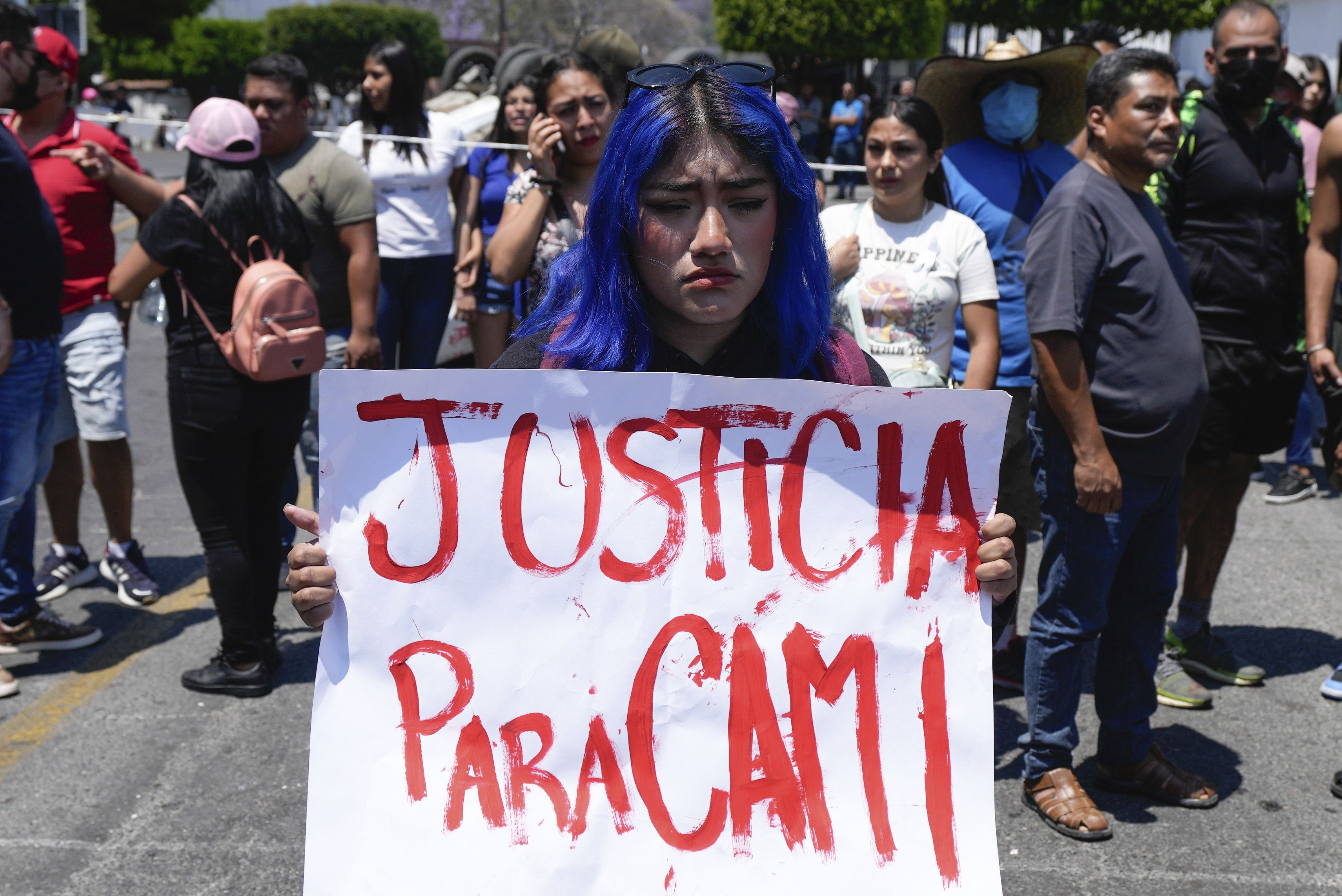 Una mujer con un cartel en el que pide justicia por la desaparición y muerte de Camila. El cuerpo de la menor de ocho años, que desapareció el miércoles, fue encontrado en una carretera a las afueras de la ciudad el jueves 28 de marzo. (AP Foto/Fernando Llano)