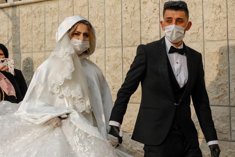 Una boda en medio de la pandemia del coronavirus, con guantes descartables y barbijos