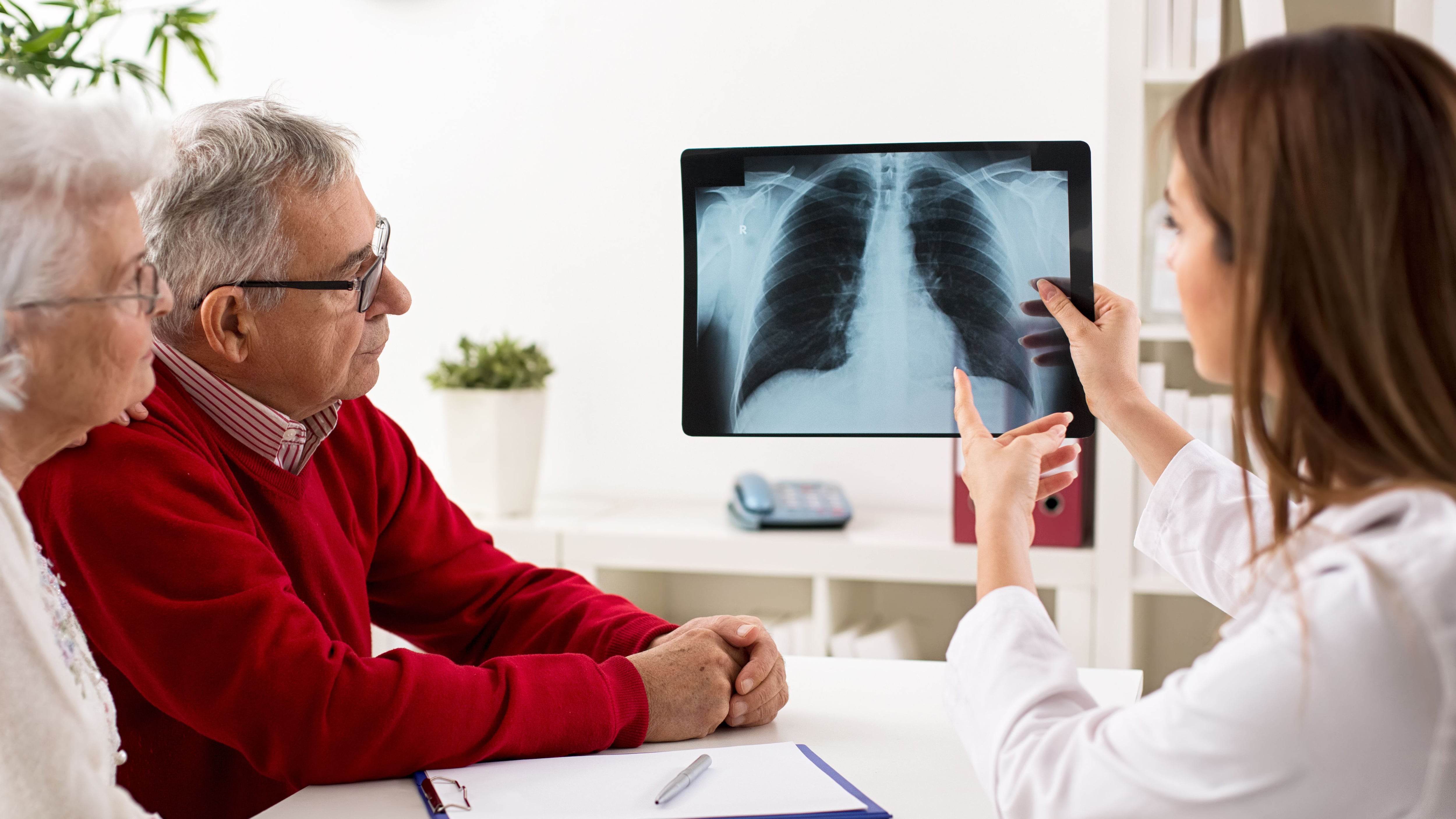 Pacientes en una consulta observando una radiografía de pulmón (Shutterstock)