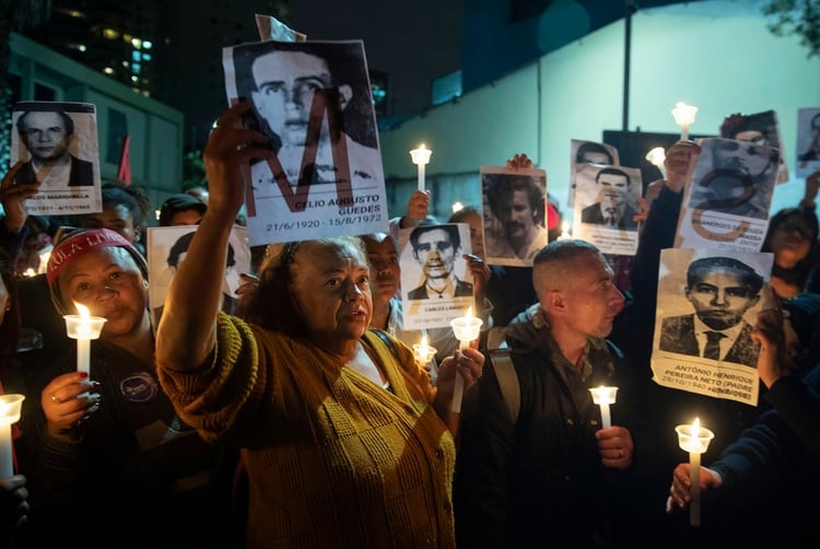 En esta fotografÃ­a del 5 de agosto de 2019, manifestantes sostienen fotos de las personas asesinadas durante la dictadura de Brasil afuera de una estaciÃ³n policial que era un centro de tortura en la dictadura en Sao Paulo, Brasil. (AP Foto/Andre Penner, Archivo)