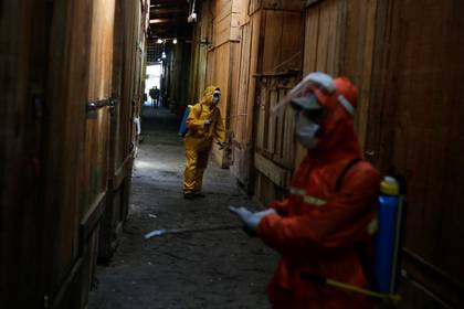 Trabajadores municipales desinfectan los puestos en el mercado de Comayaguela como parte de las medidas contra la propagación del coronavirus en Tegucigalpa, el 20 marzo 2020 (REUTERS/Jorge Cabrera)