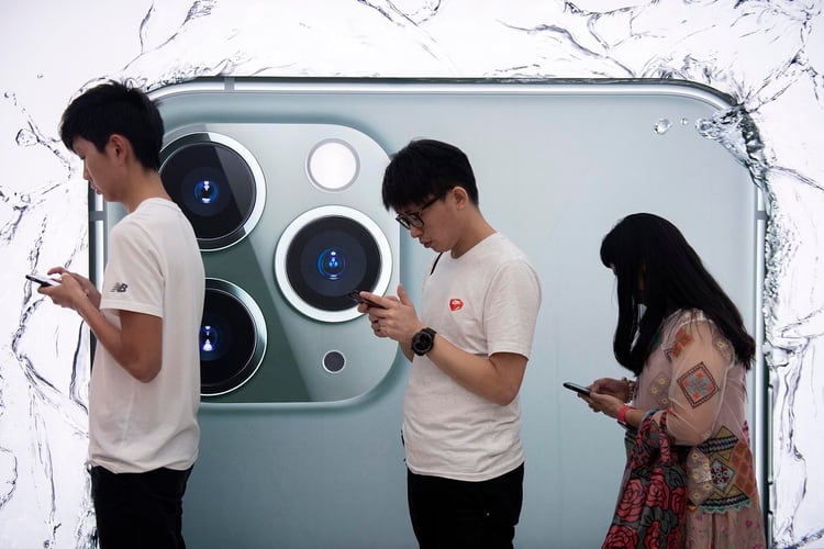 Gente haciendo fila para poder probar el nuevo iPhone en una tienda en Hong Kong. (Photo by NICOLAS ASFOURI / AFP)