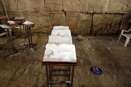 Puestos de oración cubiertos de nieve en el Muro Occidental, el lugar de oración más sagrado del judaísmo, en la ciudad vieja de Jerusalén, el 18 de febrero de 2021. REUTERS / Ronen Zvulun