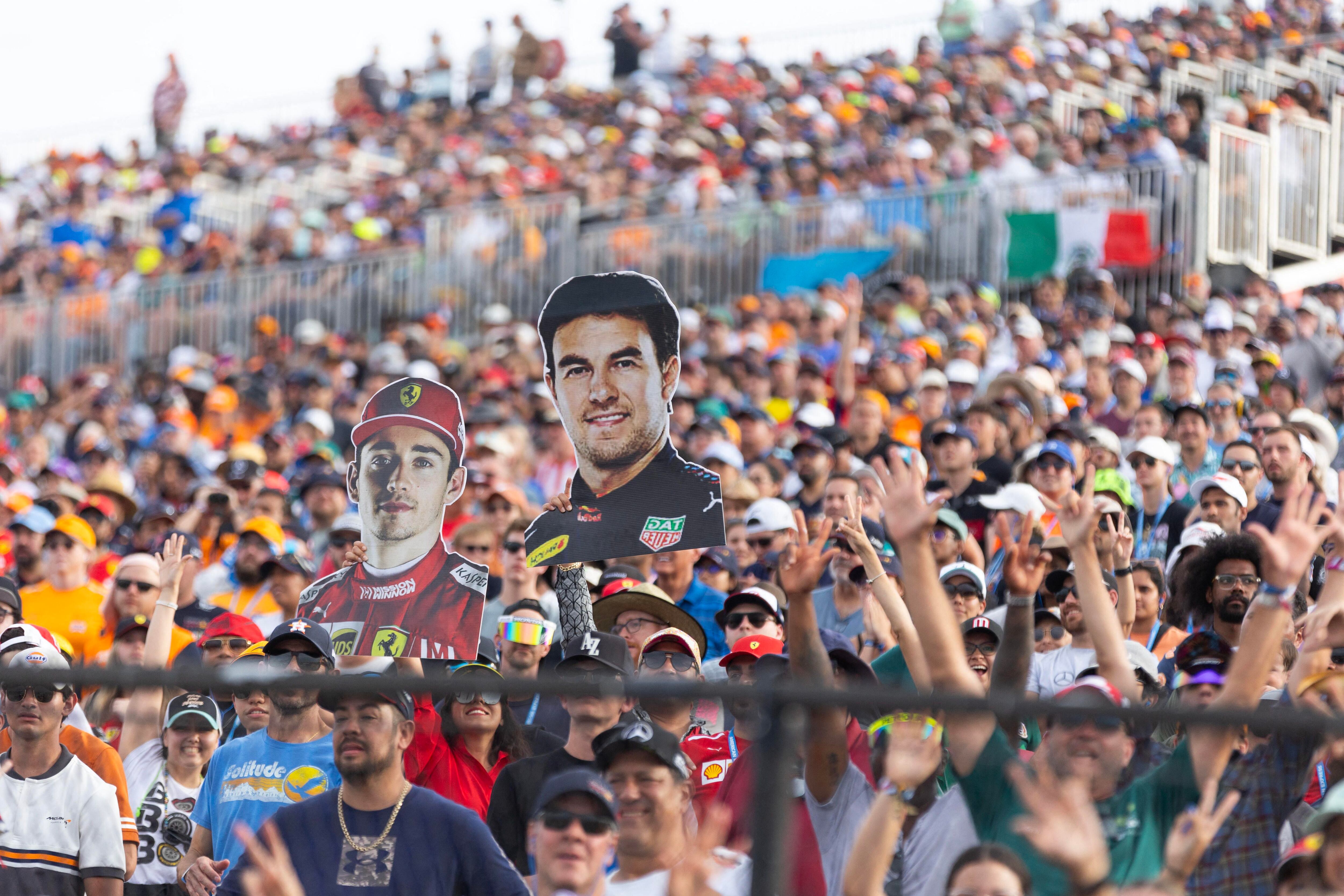Oct 21, 2023; Austin, Texas, USA; Racing fans hold up likenesses of Charles Leclerc of Ferrari and Sergio Perez of Red Bull Racing during the Sprint Race of the 2023 United States Grand Prix at Circuit of the Americas. Mandatory Credit: Erich Schlegel-USA TODAY Sports