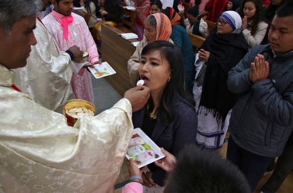 Una mujer recibe la comunión durante la misa de Navidad en Agartala, India (REUTERS/Jayanta Dey)