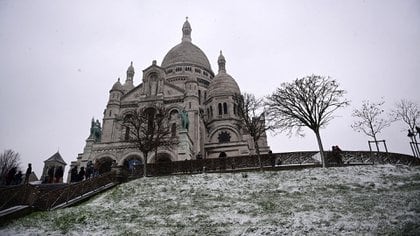 Una foto tomada el 16 de enero de 2021 muestra la Basílica del Sagrado Corazón en la cima de la colina de Montmartre después de la nevada en París (Foto de MARTIN BUREAU / AFP)
