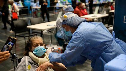 Una enfermera aplica una vacuna contra la covid-19 a un adulto mayor en el coliseo Movistar Arena, en Bogotá (Colombia). EFE/Carlos Ortega/Archivo
