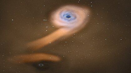 Un dibujo de un par de agujeros negros, con el de arriba acumulando material de una estrella moribunda, mientras que el de abajo rompe la corriente de escombros (ESA)
