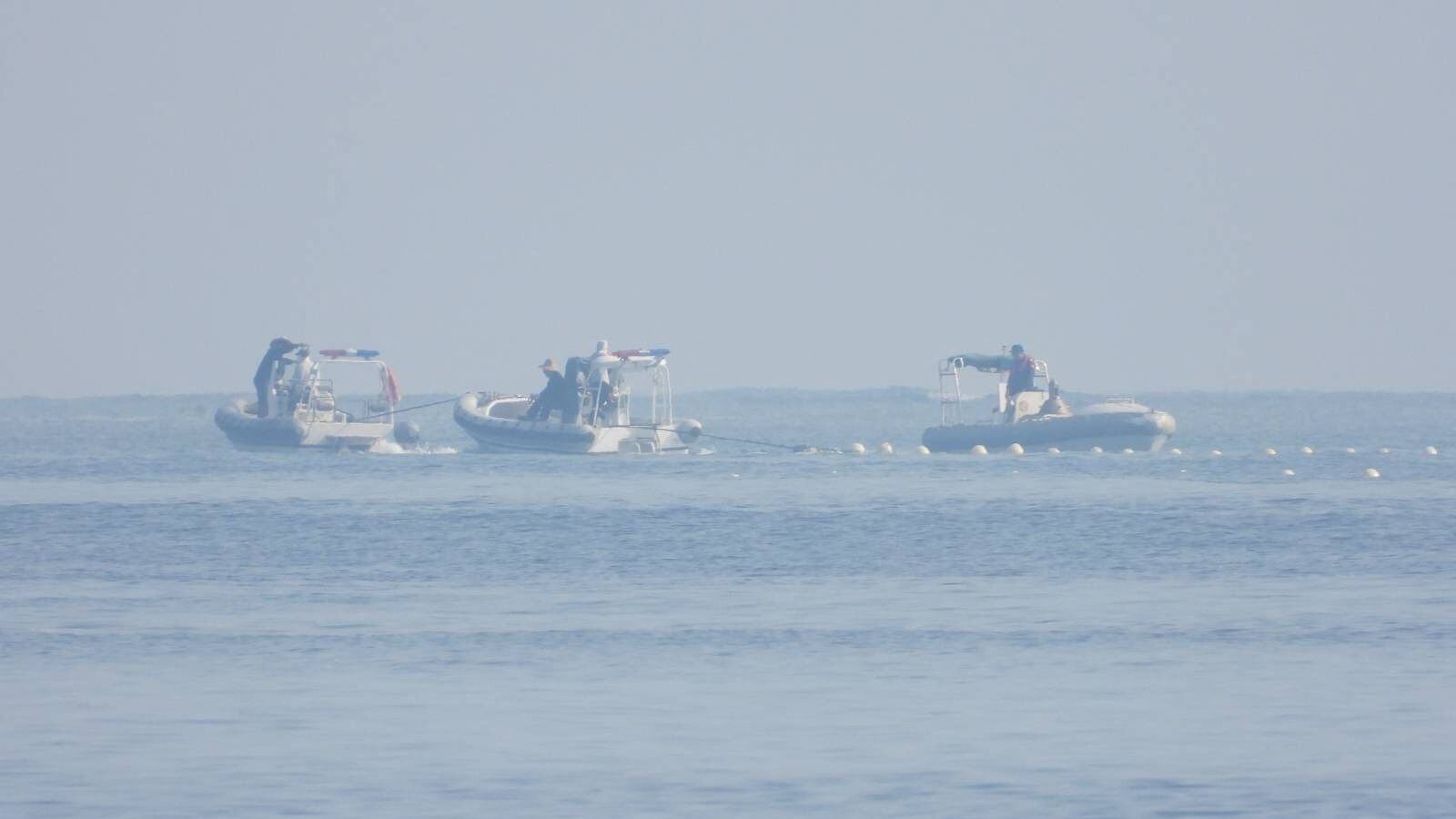Barcos de la Guardia Costera china, cerca a la barrera flotante (via Reuters)