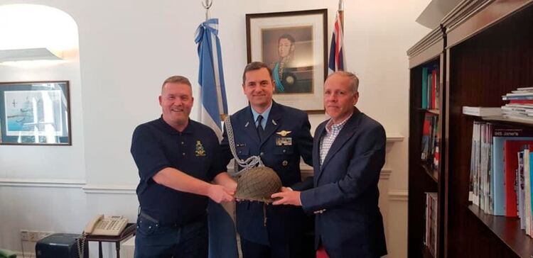 Damstag junto a Adriám Venis y el capitán Moretto, funcionarios de la embajada argentina en Londres, el día que entregó el casco