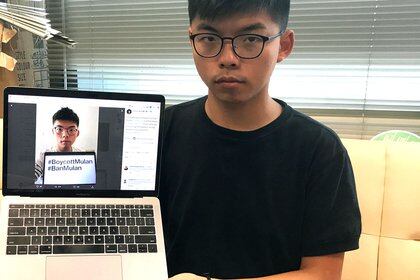 Pro-democracy activist Joshua Wong holds a laptop displaying his Twitter post which calls for a boycott of Disney's film "Mulan", as he poses for a photo in Hong Kong, China September 8, 2020. REUTERS/Aleksander Solum
