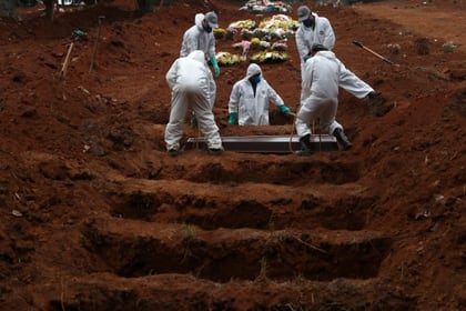 Sepultureros con trajes protectores entierran el ataúd de José Soares, de 48 años, quien murió a causa de COVID-19 (Reuters)