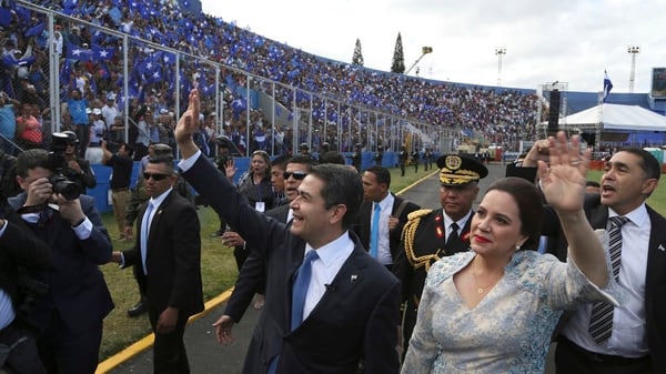 El presidente de Honduras, Juan Orlando Hernández, saluda a su llegada con su esposa Ana García para jurar para un segundo mandato, en el Estadio Nacional de Tegucigalpa, Honduras, el sábado 27 de enero de 2018 (AP)