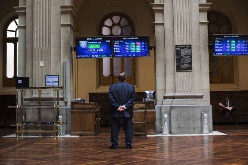FOTO DE ARCHIVO: Un hombre contempla varios paneles electrónicos con datos de cotización en el interior de la Bolsa de Madrid, España, el 29 de junio de 2012.