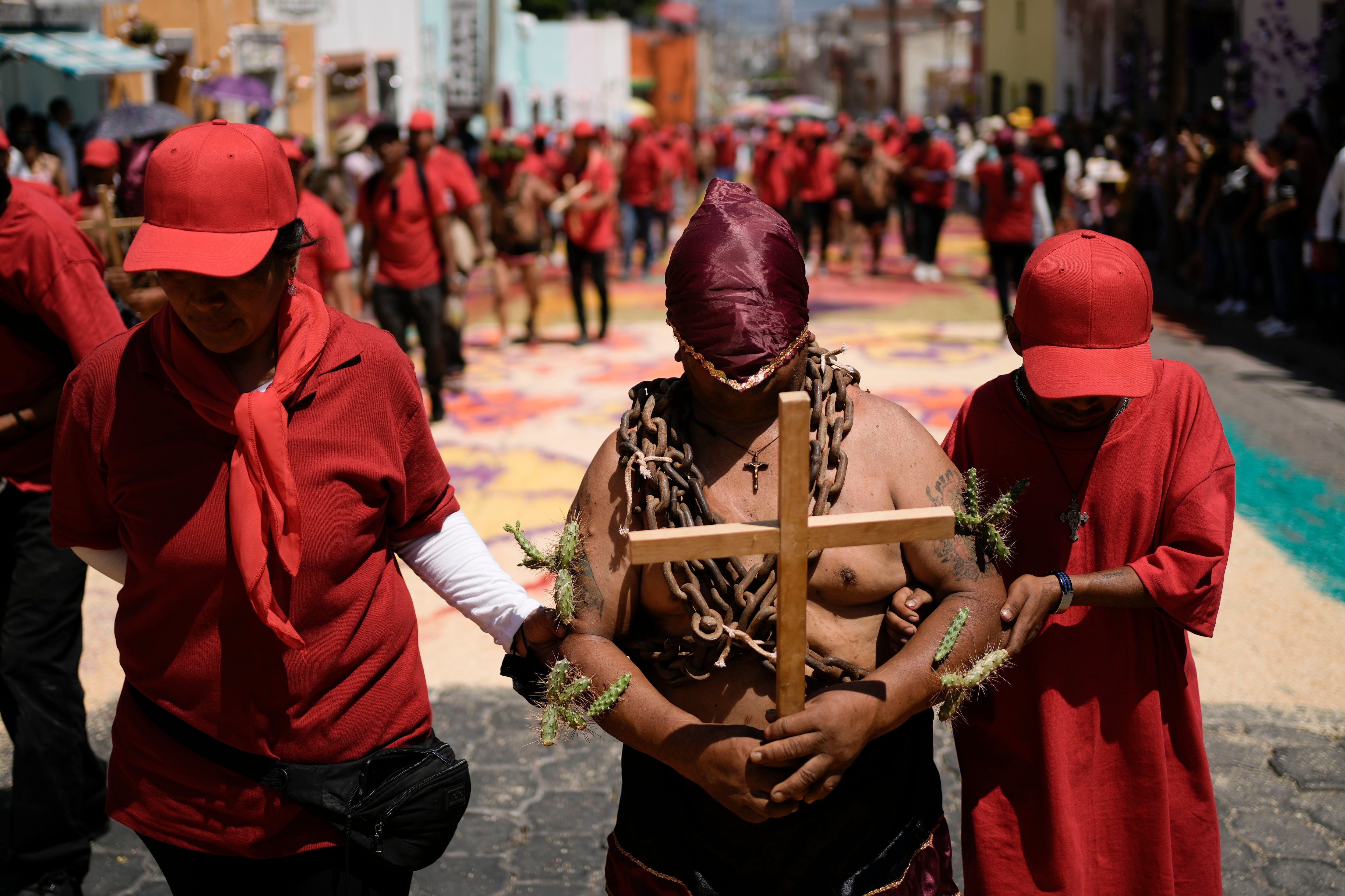 Un hombre hace penitencia con una cadena en el cuello y nopales espinosos sobre la piel, el viernes 7 de abril de 2023, en una procesión del Viernes Santo en Atlixco, México. (AP Foto/Eduardo Verdugo)