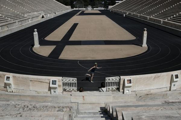Toruistas visitan el Estadio Panathinaikó, en Atenas, reconstruido a partir de los restos de un antiguo estadio griego (AP)