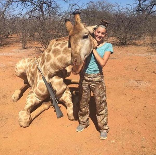 La niña sostiene la cabeza de la jirafa sin vida (Facebook)
