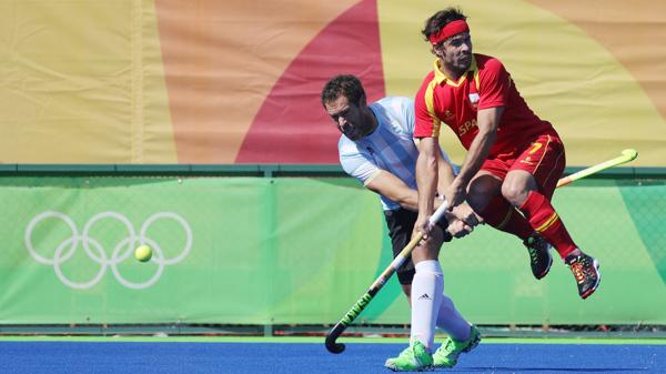 El argentino Juan Gilardi y el español Pau Quemada pelean la posesión de una bocha durante una de las llaves de cuartos de final del hockey masculino de Río 2016 (EFE)