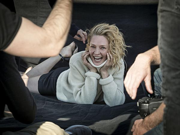 Uma Thurman- al natural- con muy poco maquillaje, cabello suelto y ondas naturales en el backstage del almanaque (Pirelli)