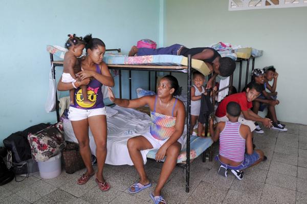 Una familia refugiada en un centro de asistencia por la legada del huracán Matthew (AFP)