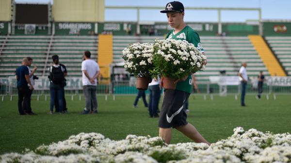 Un niño acomoda las flores para la ceremonia principal (AFP)