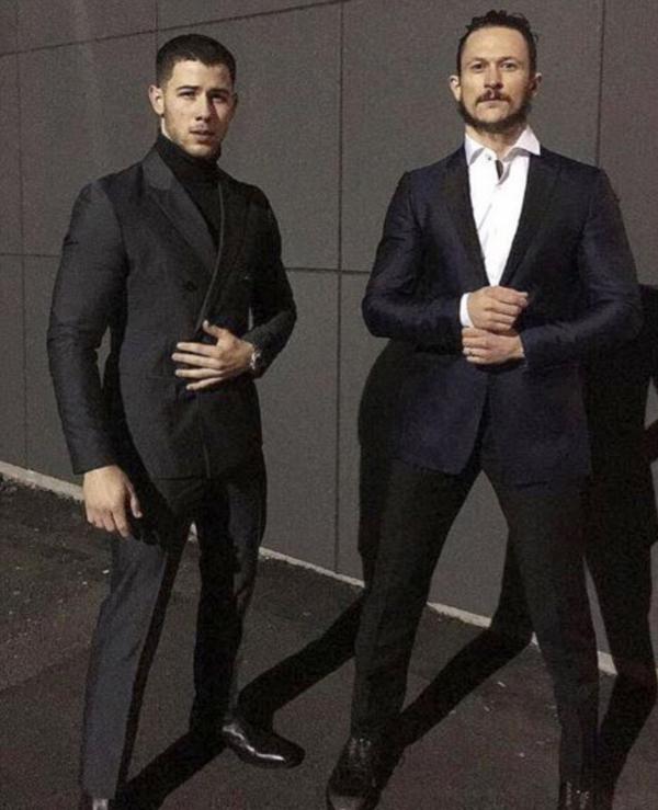El cantante Nick Jonas llegó a la Casa Blanca y se mostró con un traje gris oscuro. Posó con Jonathan Tucker