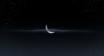 Escena minimalista de cielo nocturno oscuro con una luna creciente apenas visible, rodeada por una fina neblina y estrellas dispersas.