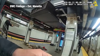 Vista en primera persona de un agente de policía apuntando un arma. Un hombre yace en el suelo del andén de la estación Grand Central. Un tren está visible
