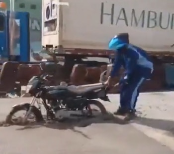 El video muestra al conductor intentando sacar la motocicleta del lugar mientras otros conductores se burlan - crédito
@ColombiaOscura/Pantallazo