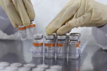 Un empleado recoge viales que