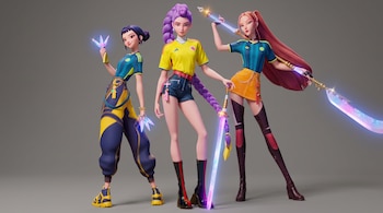 Tres personajes femeninos de animación, con camisetas de la Selección de Colombia, pantalones, faldas y botas, sostienen armas brillantes sobre un fondo gris liso.