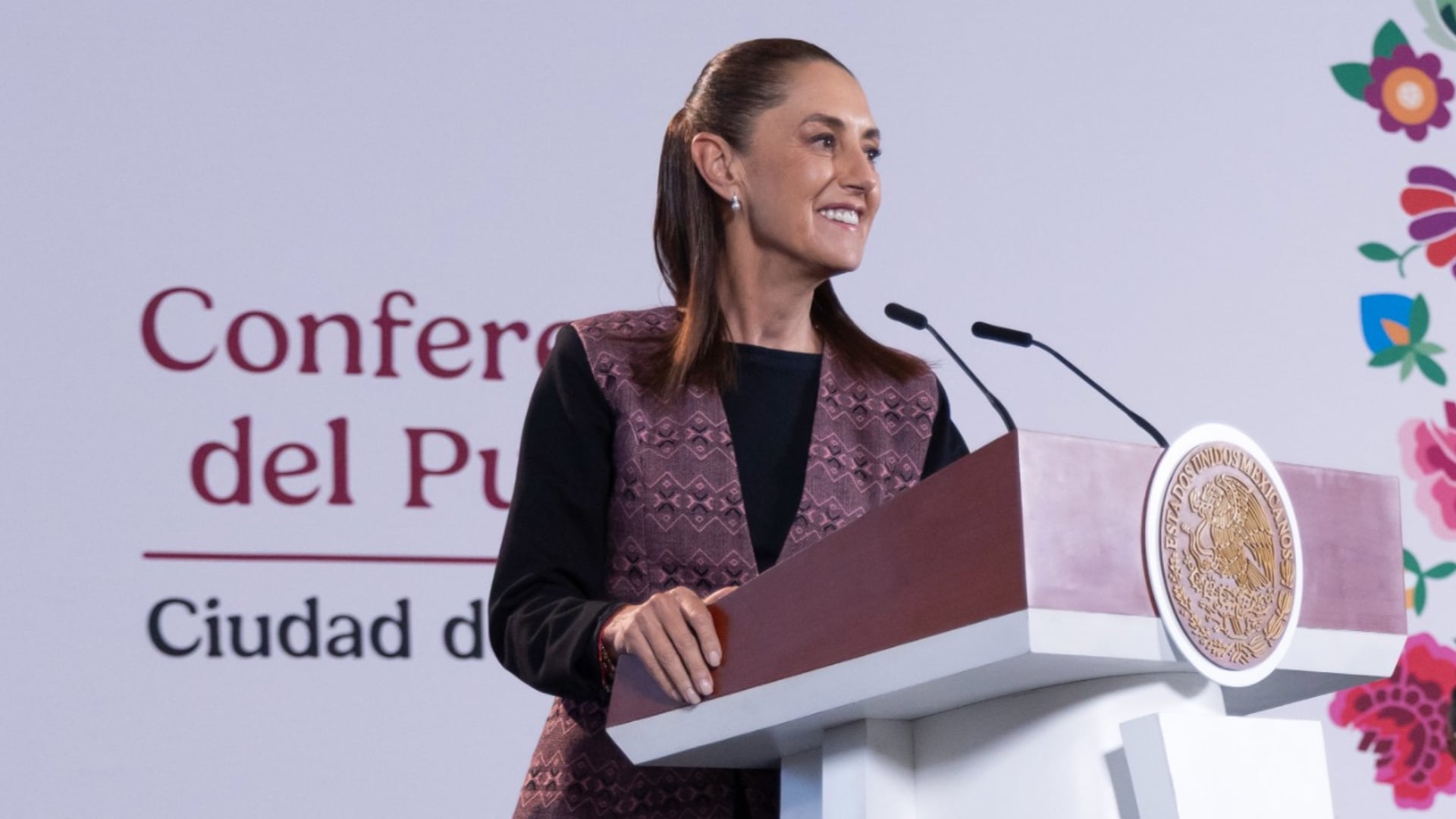 Claudia Sheinbaum habla desde un podio oficial durante la Conferencia del Pueblo en Ciudad de México. (Presidencia )