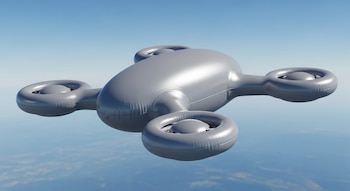 Un dron inflable de color gris, con cuatro formas redondeadas que simulan hélices, flotando bajo un cielo azul claro con una leve vista de la tierra abajo.