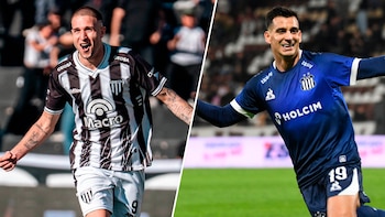 Dos futbolistas masculinos posan con sus camisetas de juego; uno con uniforme a rayas blancas y negras, el otro con uniforme azul oscuro