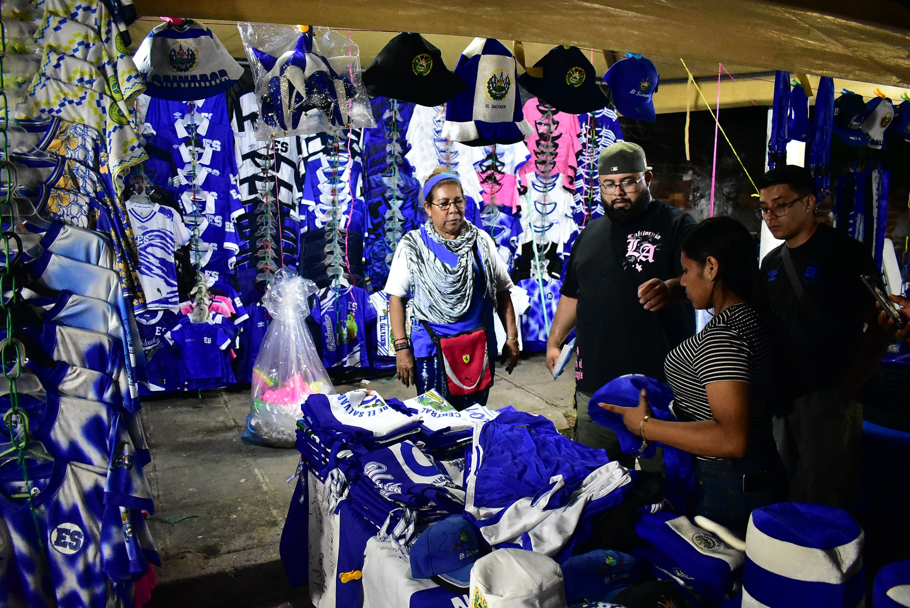 Varios comerciantes tienen en venta prendas y accesorios con la bandera de El Salvador y la selección. (Infobae Centroamérica/Emerson Del Cid)