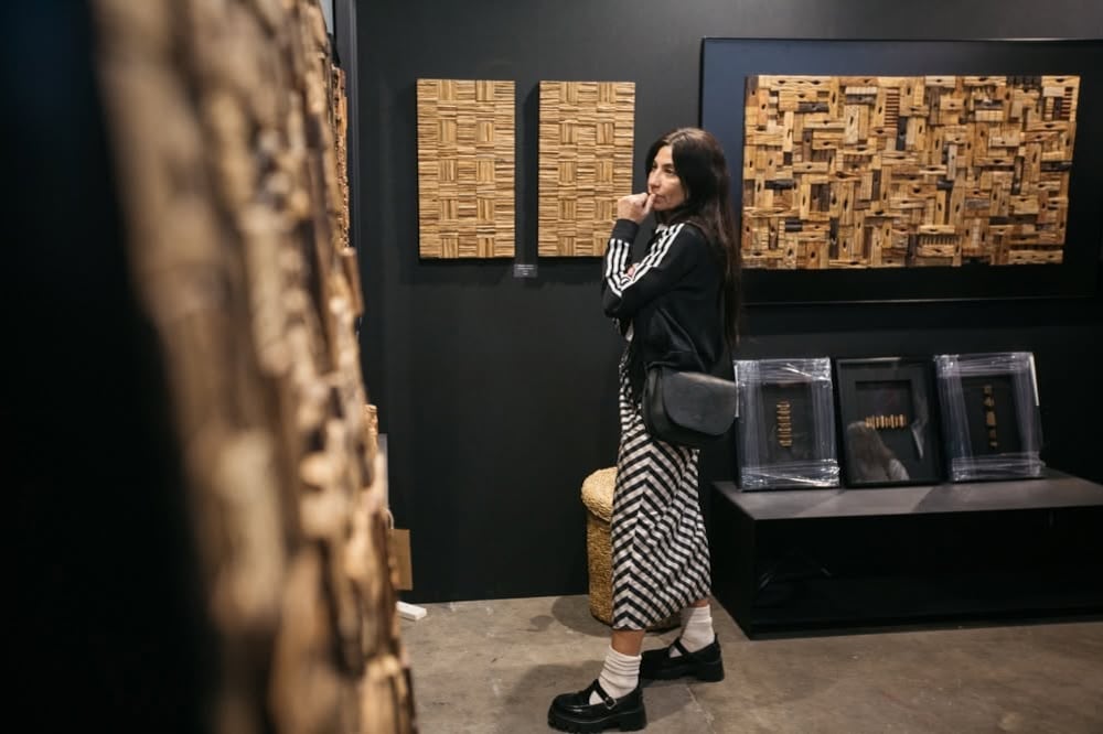 Una visitante contempla relieves y esculturas de madera expuestos durante la feria de arte BADA. (BADA)