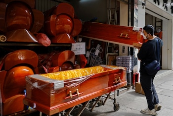 FILE PHOTO: Workers move coffins